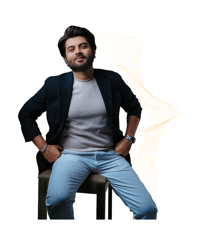 Jay Thadeshwar sitting confidently on a chair with a relaxed pose, dressed in a blazer and casual attire, with a dynamic yellow background.